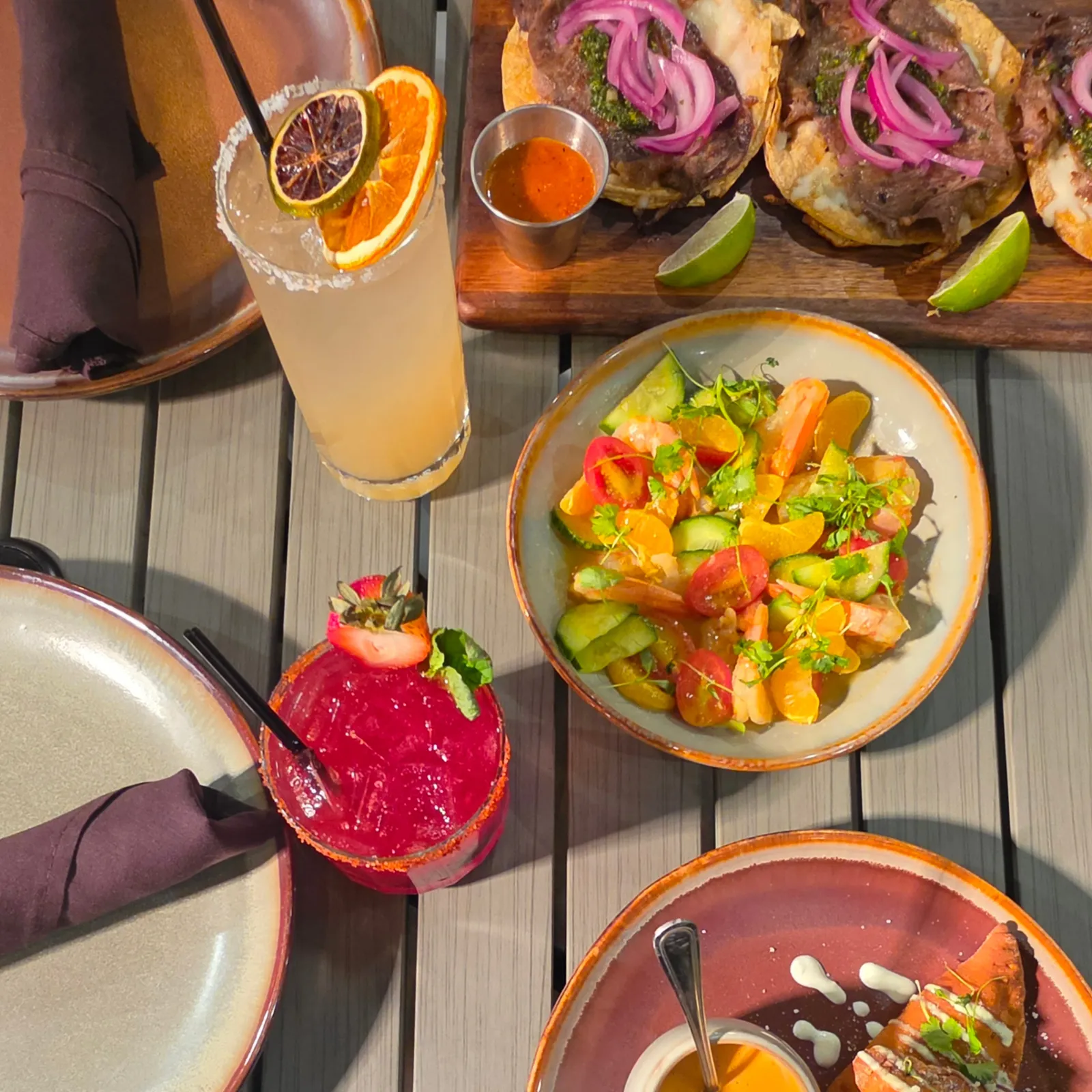 Overhead view of the patio table — cocktails, tacos, and shrimp aguachile — Casa Tequila Prime