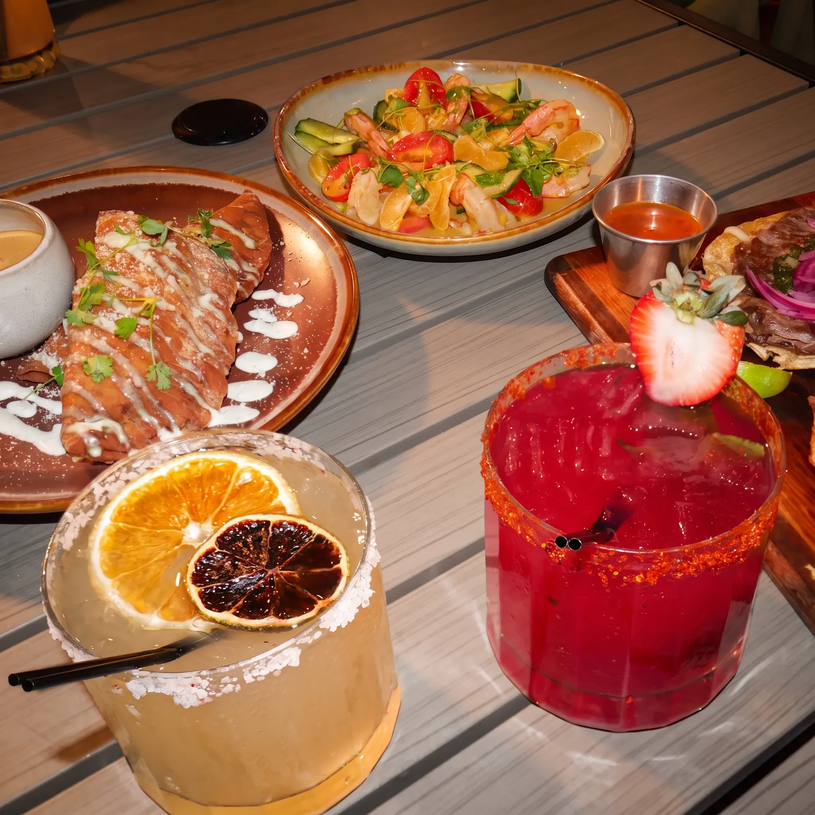 Patio table spread — shrimp aguachile, empanadas, tacos, and handcrafted cocktails — Casa Tequila Prime